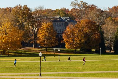 Students cross the Drillfield on clear fall day. 