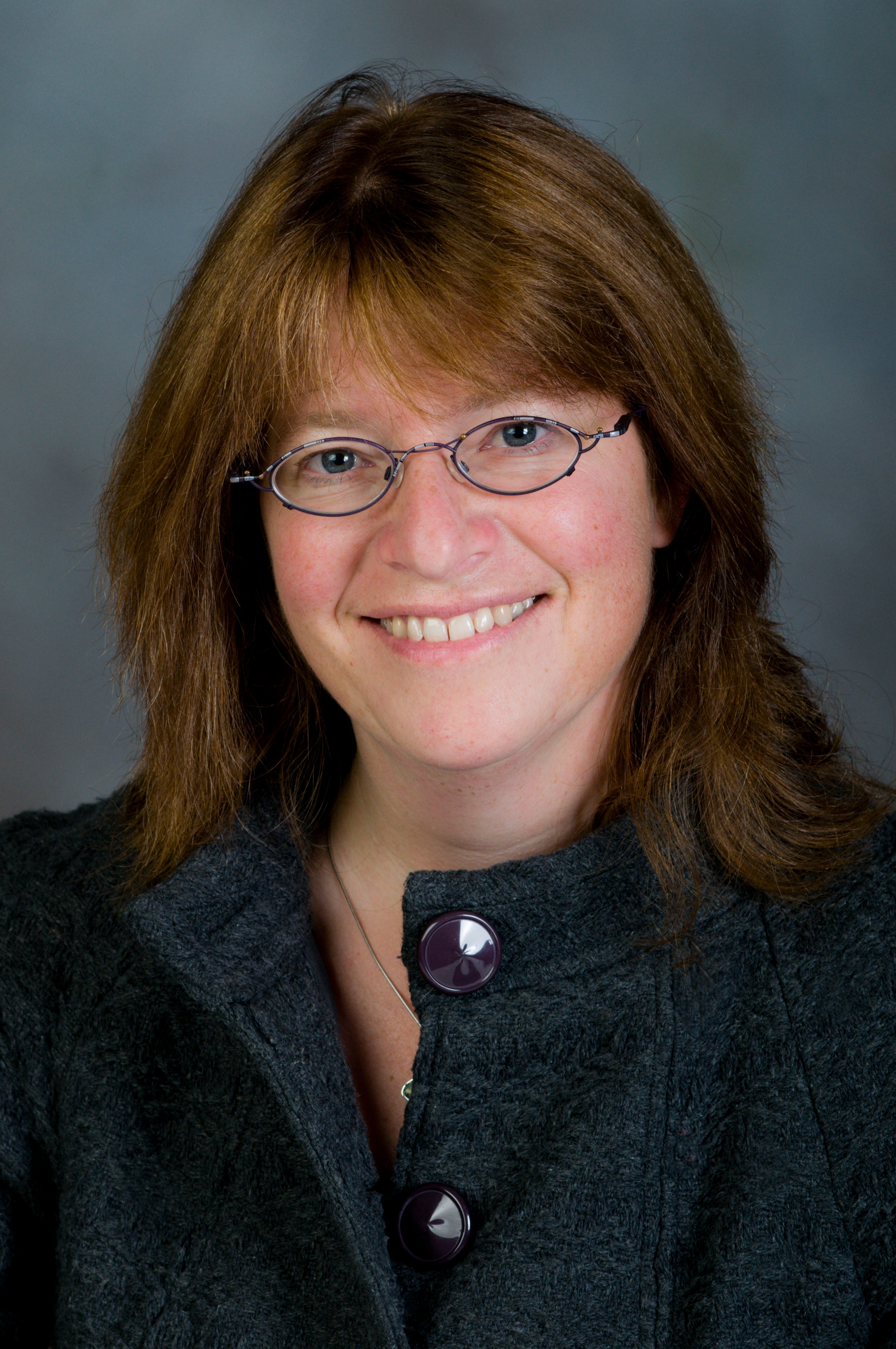 Isabel Bradburn Headshot Against Grey Backdrop 